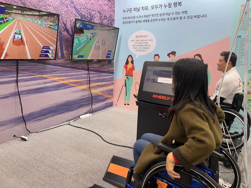 ▲ 이번 행사는 '모두를 위한 여행'의 가치를 전면에 내세우고 있다. 사진은 관람객이 휠체어 레이싱 확장현실(XR) 체험 행사에 참여하는 모습. This year's Korea Travel Expo prioritizes the value of travel for all as shown by a visitor playing an extended reality game of wheelchair racing.