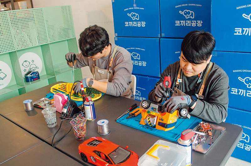 고장이 난 장난감을 수리하고 있는 코끼리공장 직원들. Kokkiri Gongjang employees repairing broken toys. ⓒ 코끼리공장 - Elephant Factory