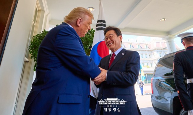 President Lee Jae Myung on Aug. 25 signs the guestbook of the Oval Office at the White House in Washington with U.S. President Donald Trump looking on. (Office of the President)