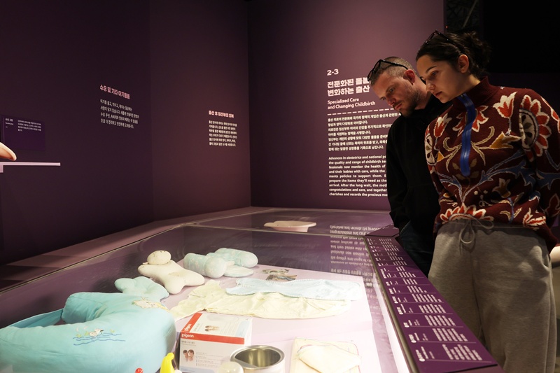 ▲ 외국인 관람객이 현대 육아 용품을 살펴보고 있다. Visitors explore exhibits of modern childcare products.