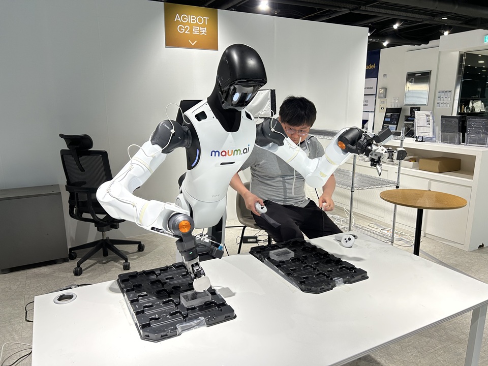 ▲ 캔을 박스에 넣고 빼는 작업을 학습하고 있는 로봇. The photo shows a humanoid robot that learns to insert and remove cans from a box at Maum AI's headquarters in Seongnam City, Gyeonggi-do Province.